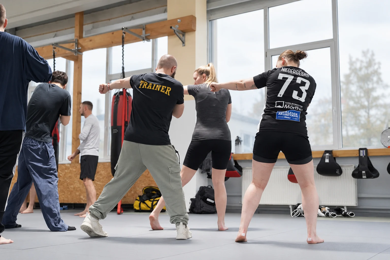 Ein Boxtrainer erkl&auml;rt zwei Teilnehmerinnen die Schlagbewegung